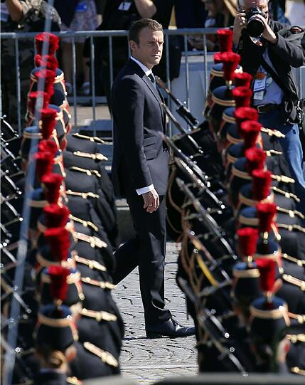 Macron schreitet auf den Champs-Élysées durch die Reihen.