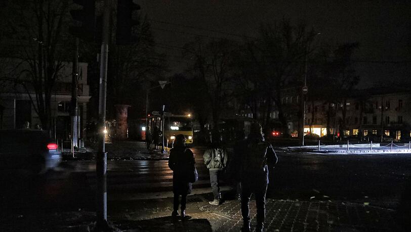 Fußgänger halten sich in Odessa an einer Kreuzung auf einer dunklen Straße auf, da die Stadt von Stromausfällen betroffen ist. Fußgänger halten sich in Odessa an einer Kreuzung auf einer dunklen Straße auf, da die Stadt von Stromausfällen betroffen ist.