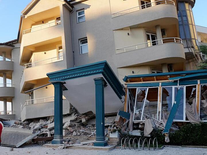 Nach dem Erdbeben stehen zwei Männer neben einem beschädigten Gebäude in Durres.