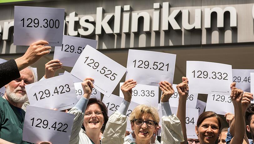 Angestellte der Münchner Universitätsklinik Großhandern halten Nummern in die Luft, die fehlende Stellen symbolisieren. Angestellte der Münchner Universitätsklinik Großhandern halten Nummern in die Luft, die fehlende Stellen symbolisieren.