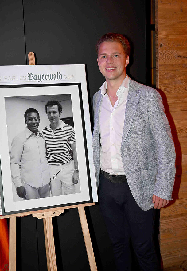 Joel Beckenbauer, der Sohn von Franz Beckenbauer, macht seinem verstorbenen Vater als neuer Stiftungsvorstand alle Ehre. Hier präsentiert er ein Foto, das seinen Vater und dessen Fußball-Kollege Pelé zeigt.