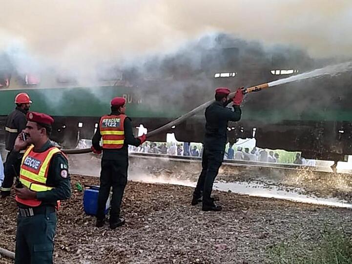 Rettungskräfte der Feuerwehr versuchen, das Feuer des Personenzuges zu löschen.