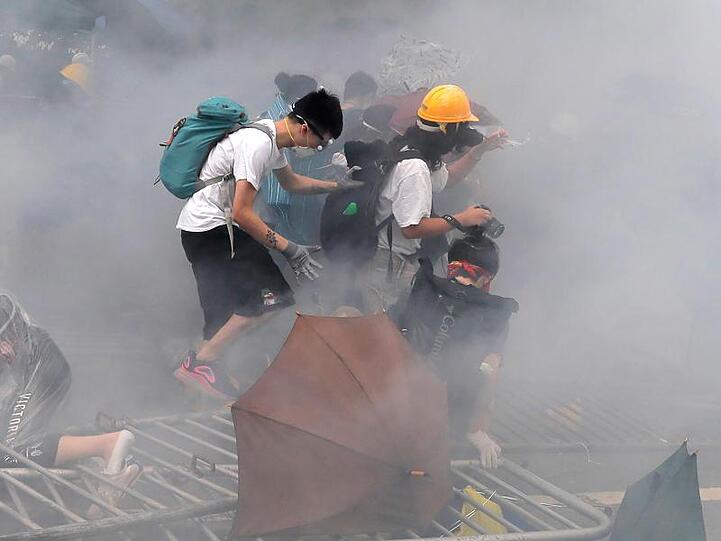 Demonstranten schützen sich mit Gesichtsmasken vor dem Tränengas der Hongkonger Sicherheitskräfte.