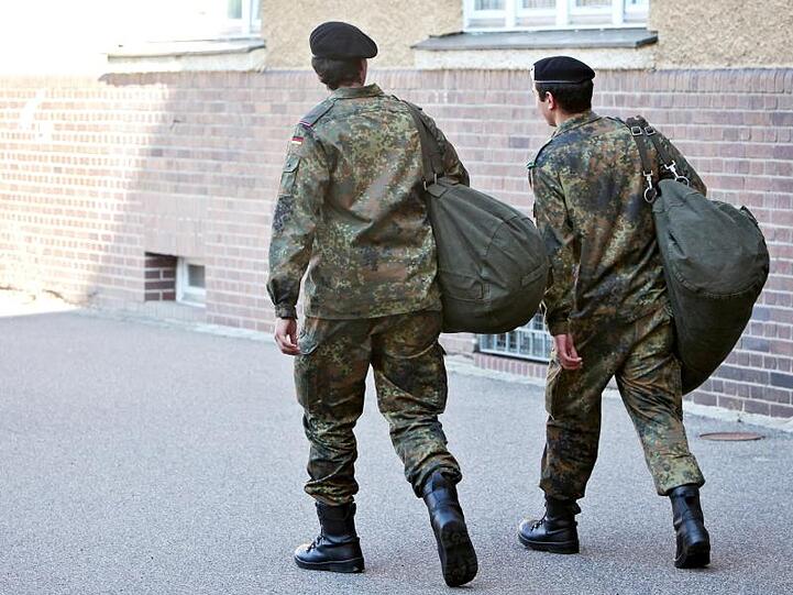 Zwei ausscheidende Wehrdienstleistende verlassen nach ihrer offiziellen Verabschiedung die Kaserne. Foto: Daniel Karmann/dpa/Archivbild