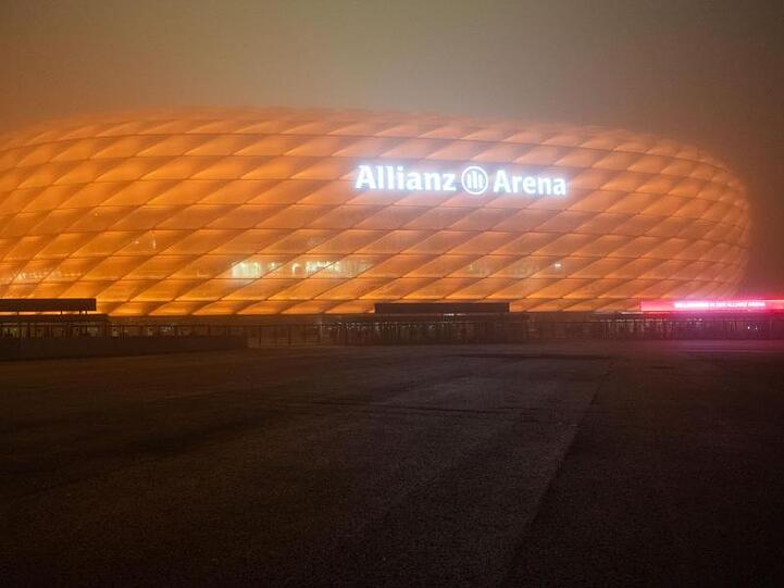 Die Allianz Arena ist orange beleuchtet. Foto: Lino Mirgeler/dpa/Archivbild