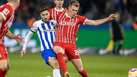 Herthas Suat Serdar (l) kämpft mit Freiburgs Matthias Ginter um den Ball.
