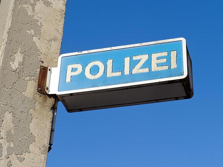 Blick auf das Hinweisschild eines Polizeireviers. Foto: Stefan Sauer/Archiv