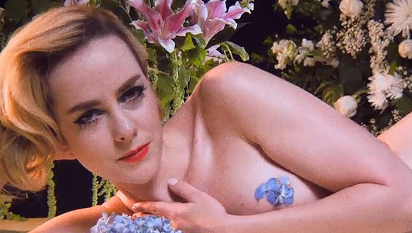 Jena Malone räckelt sich in einem Meer aus Blüten auf einem Klavier Jena Malone räckelt sich in einem Meer aus Blüten auf einem Klavier