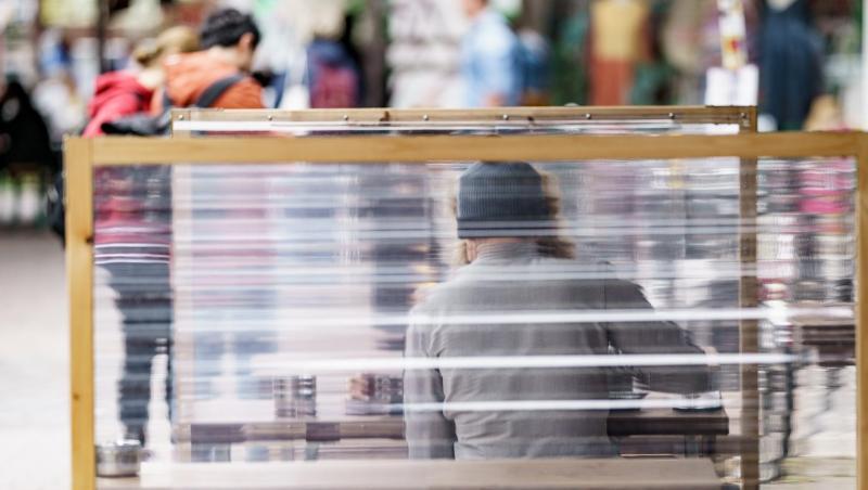 Gäste eines Restaurants warten zwischen Plexiglas-Trennscheiben auf ihre Bestellung. In Hamburg gilt ab dem Wochenende die sogenannte 2G Regelung.