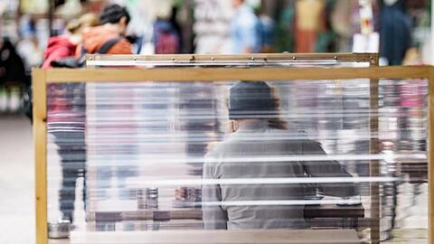Gäste eines Restaurants warten zwischen Plexiglas-Trennscheiben auf ihre Bestellung. In Hamburg gilt ab dem Wochenende die sogenannte 2G Regelung.