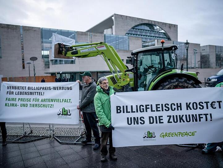 Aktivisten der "Arbeitsgemeinschaft bäuerliche Landwirtschaft" und der Umweltschutzorganisation Greenpeace stehen mit Transparenten vor dem Kanzleramt.