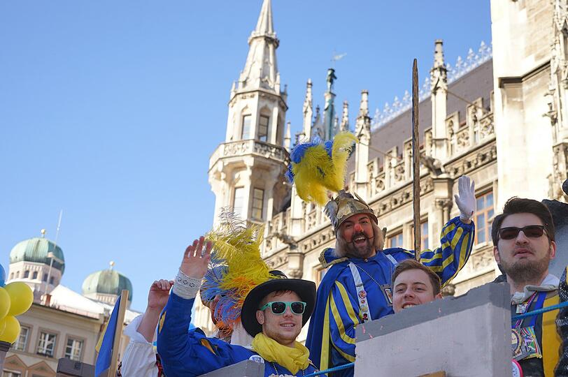 Kazimir, der Damische Ritter mit der roten Nase, winkt faschingshuldvoll in die Menge. Seine damischen Spezln winken den Zuschauern am Marienplatz nicht weniger motiviert zu.