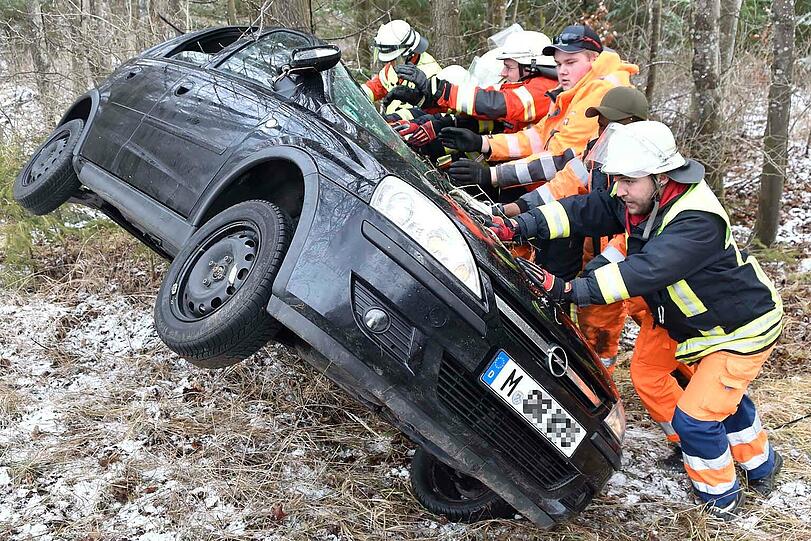 Die Einsatzkräfte aus Grasbrunn und Harthausen stellen das Autowrack wieder auf die Räder.