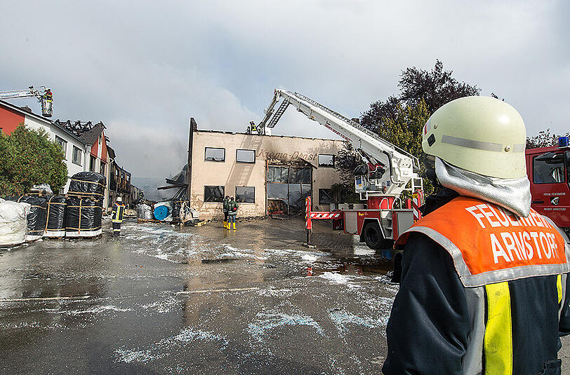 Rauch steigt am aus einer völlig ausgebrannten Kunststoff-Fabrik in Malgersdorf auf. Bei dem Brand in der Folienfabrik ist am frühen Samstagmorgen ein Schaden von mehreren Millionen Euro entstanden.