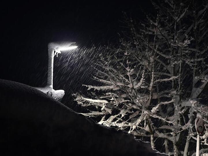 Fallender Schnee wird von einer Straßenlaterne beleuchtet. Foto: Karl-Josef Hildenbrand
