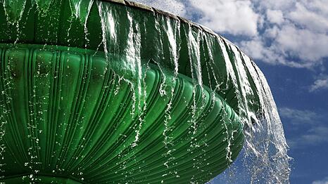 Äußerst pittoresk schwappt das Wasser aus dem oberen Becken des Uni-Brunnens nach unten - darüber ein weiß-blauer Himmel. Was will man mehr?