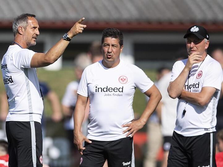 Frankfurts Trainer Adi Hütter (l) bespricht sich mit seinen Assistenten Christian Peitinger (M) und Armin Reutershahn.