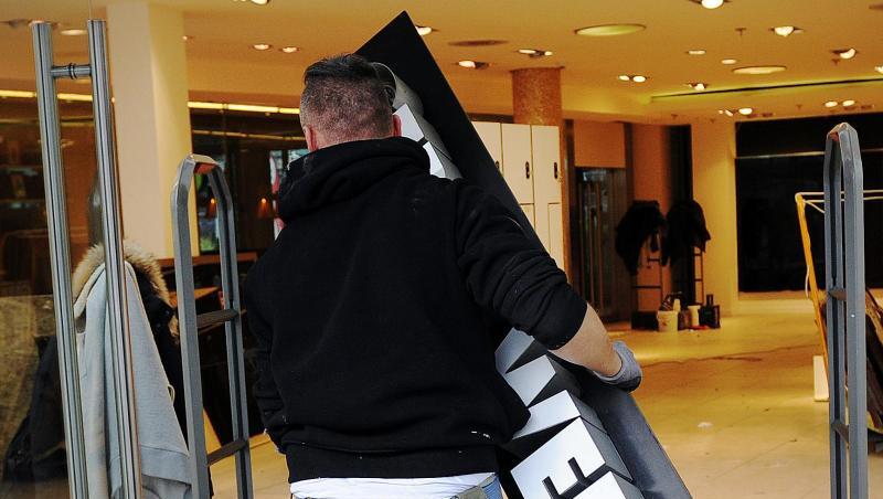 Ein Trockenbau-Monteur hängt ein Schild mit dem Schriftzug "Gerry Weber" an einer geschlossenen Filiale der Modemarke ab. Ein Trockenbau-Monteur hängt ein Schild mit dem Schriftzug "Gerry Weber" an einer geschlossenen Filiale der Modemarke ab.