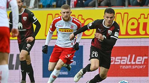 Der Regensburger Jan-Niklas Beste (l) und Florian Pick vom FC Ingolstadt kämpfen um den Ball.