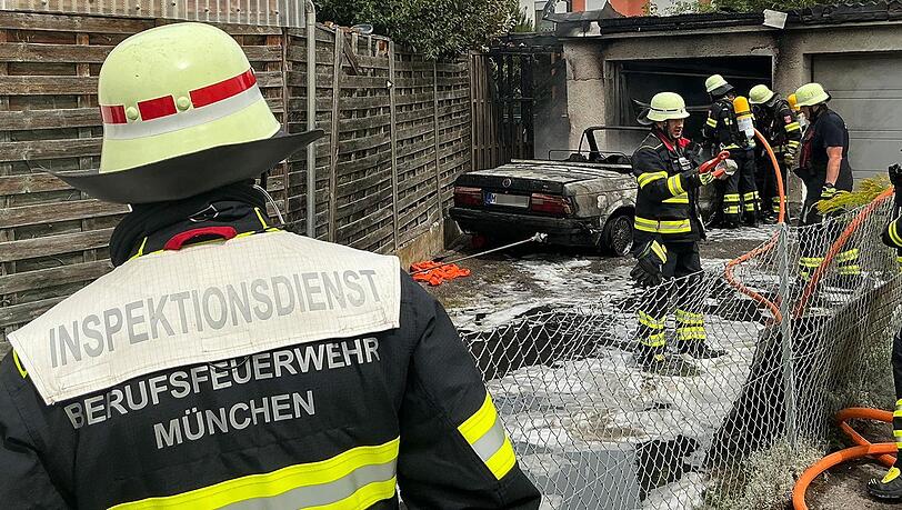Einsatzkräfte der Feuerwehr München bei einem Pkw-Brand. Einsatzkräfte der Feuerwehr München bei einem Pkw-Brand.
