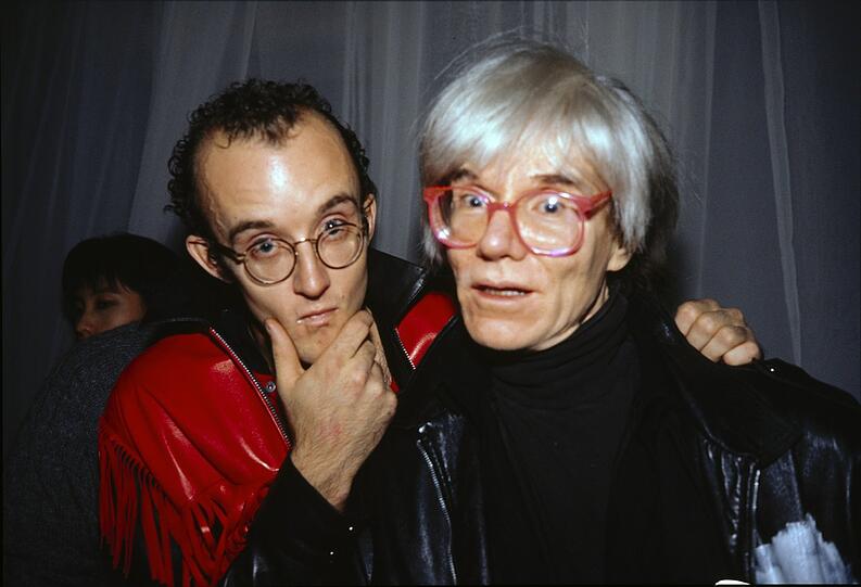 Erst hat sich Keith Haring (links) nicht getraut, den großen Andy Warhol anzusprechen. Dann sind die beiden aber schnell Freunde geworden. Und in diesem Fall wurden sie gleich noch im New Yorker Palladium Club von einer fabelhaften Szenefotokünstlerin abgelichtet: Nan Goldin.