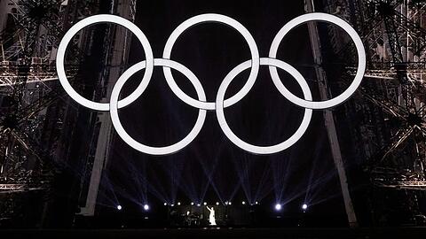 Céline Dion auf dem Eiffelturm unter den olympischen Ringen.