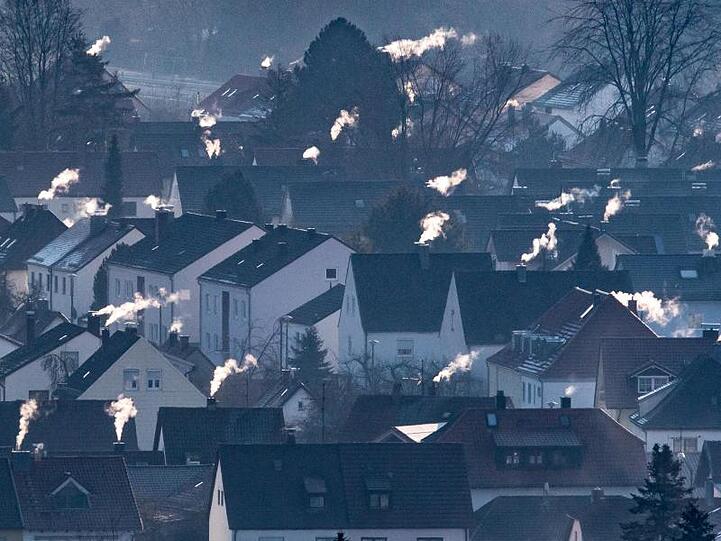 Schornsteine rauchen auf den Dächern der Häuser. Im Herbst sollen konkrete Maßnahmen und Gesetze für mehr Klimaschutz kommen.
