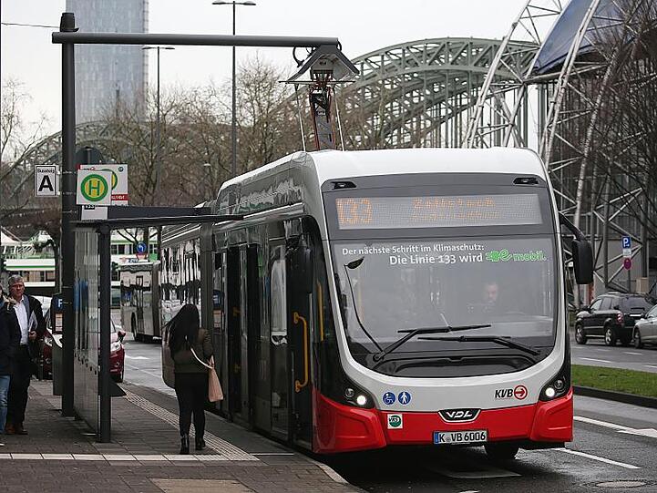 Ein Elektrobus der Kölner Verkehsbetriebe (KVB) wird an einer Haltestelle aufgeladen.