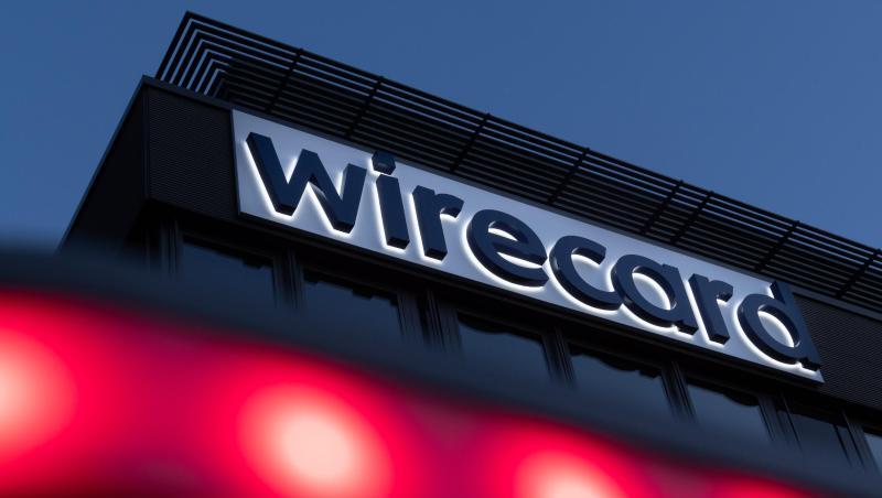 Rote Lichter leuchten vor dem Schriftzug von Wirecard an der Firmenzentrale. Foto: Peter Kneffel/dpa/Archivbild