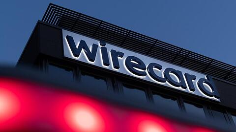 Rote Lichter leuchten vor dem Schriftzug von Wirecard an der Firmenzentrale. Foto: Peter Kneffel/dpa/Archivbild