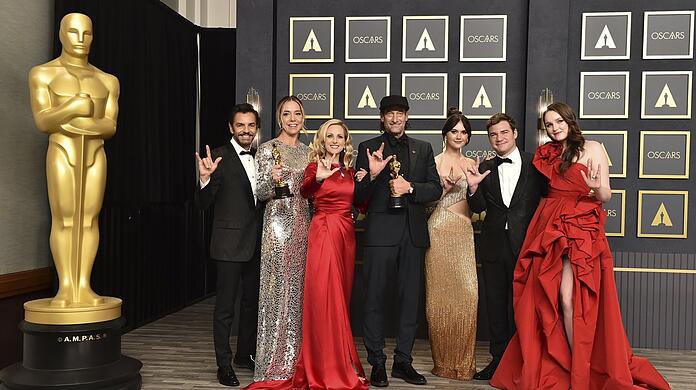 Eugenio Derbez (links), Sian Heder, Marlee Matlin, Troy Kotsur, Emilia Jones, Daniel Durant und Amy Forsyth, Gewinner des Preises für den besten Film für "Coda", zeigen im Presseraum der 94. Verleihung der Academy Awards in Hollywood ihre Oscars und das Gebärdenzeichen für "I Love You".