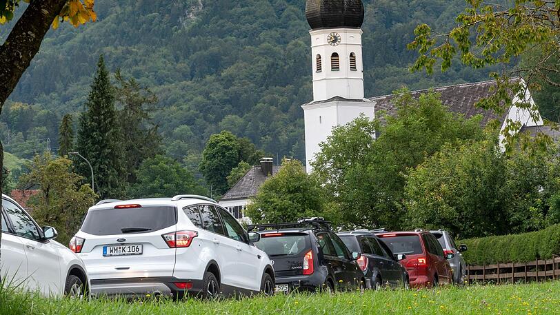 Autos stehen während einer Demonstration für eine Verkehrswende im Oberland unter dem Motto "Ausbremst is!" vor der Ortschaft im Stau. Die Demonstration soll sich nicht gegen Touristen, sondern gegen das steigende Verkehrsaufkommen und das wachsende Müllproblem richten, das durch den Tourismus entsteht.