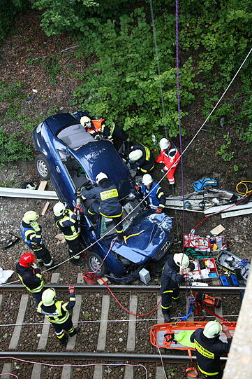 Furchtbarer Unfall im Landkreis Altötting: Ein PKW fliegt von einer Brücke herunter und knallt auf das Gleisbett. Drei junge Menschen kommen schwer verletzt in die Klinik.
