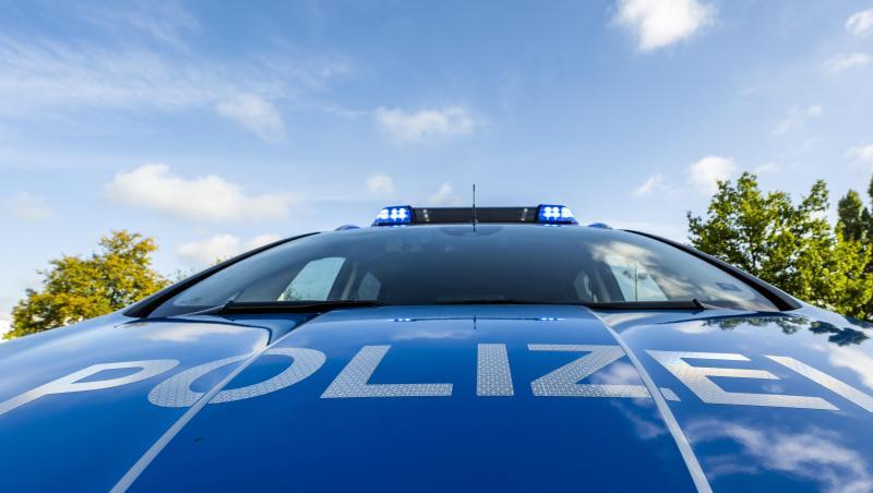 Auf der Motorhaube eines Streifenwagens steht der Schriftzug "Polizei".