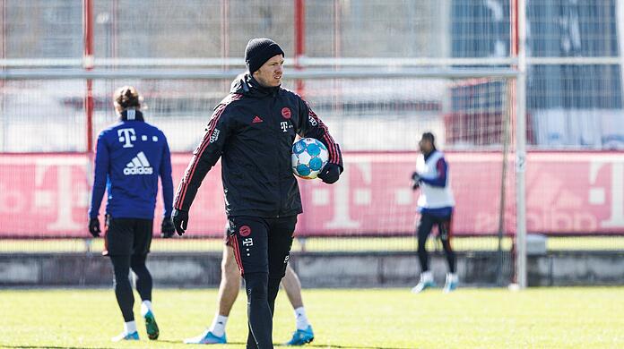 Trainer Julian Nagelsmann mit einem Ball unter dem Arm über den Platz und leitet das Training.
