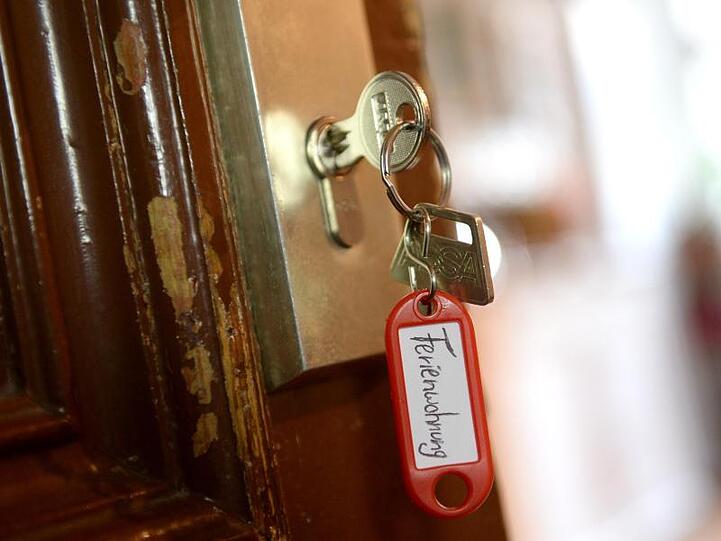 Ein Schlüssel mit der Aufschrift "Ferienwohnung" hängt an einer Wohnungstür. Foto: Britta Pedersen/Archivbild