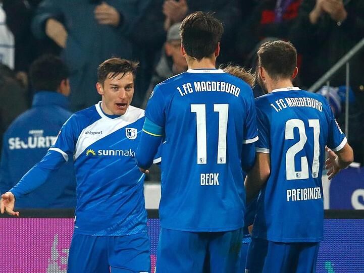Die Magdeburger Charles Elie Laprevotte (l-r), Christian Beck und Rico Preißinger jubeln nach dem Tor zum 1:0 gegen Aue.