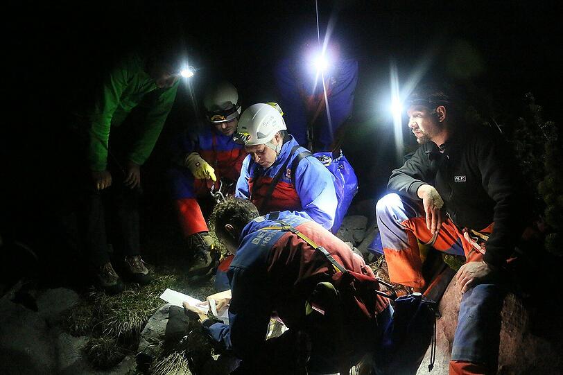 Kleines Bild: (L-R): Stefan Schneider von der Bergwacht Chiemgau, Thomas Küblböck, Leiter der Bergrettung Chiemgau und Anton Brandner, von der Feuerwehr Berchtesgaden. Großes Bild: Einsatzkräfte der Bergwacht beraten in der Nacht vom 08.06.2014 auf Pfingstmontag das weitere Vorgehen am Untersberg in rund 1800 Metern Höhe beim Eingang in die Riesending-Schachthöhle.
