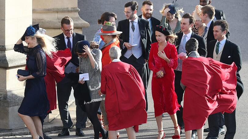 Die Gäste der royalen Hochzeit werden fast von dem stürmischen Wind weggeblasen.