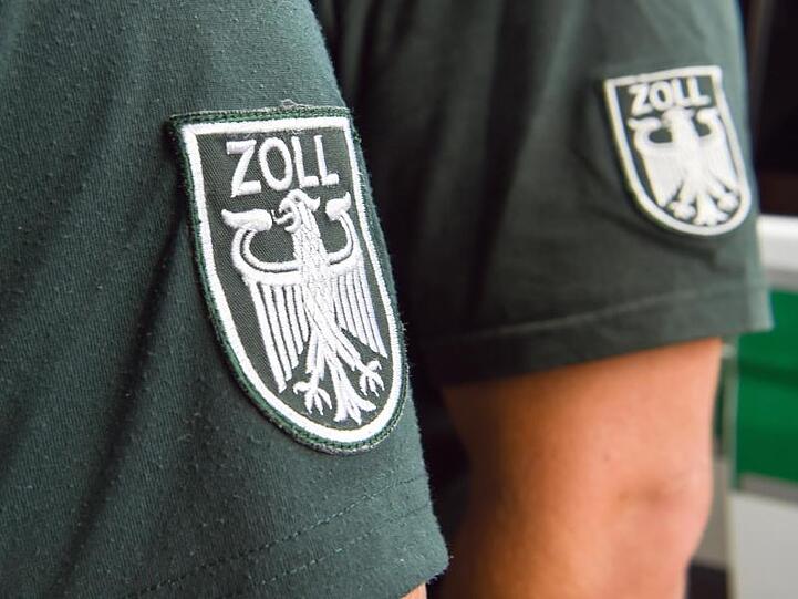 Die Ärmelabzeichen von zwei Zollbeamten. Foto: picture alliance / Christophe Gateau/dpa/Symbolbild