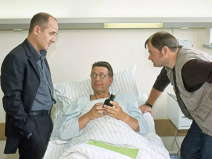 Robert Kolmaar (Ulrich Mühe, l.) und Max Kolditz (Markus Majowski, r.) besuchen Joe Hoffer (Jörg Gudzuhn, m.) im Krankenhaus.