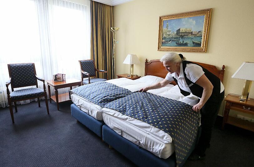 &bdquo;Extreme Nachfrage zur Wiesn&ldquo;: Eine Hotelangestellte richtet das Bett für den nächsten Gast.