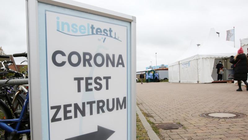 Ein Aufsteller mit der Aufschrift "Corona Testzentrum" weist den Weg zu einem Testzentrum am Bahnhof Westerland in Schleswig-Holstein.