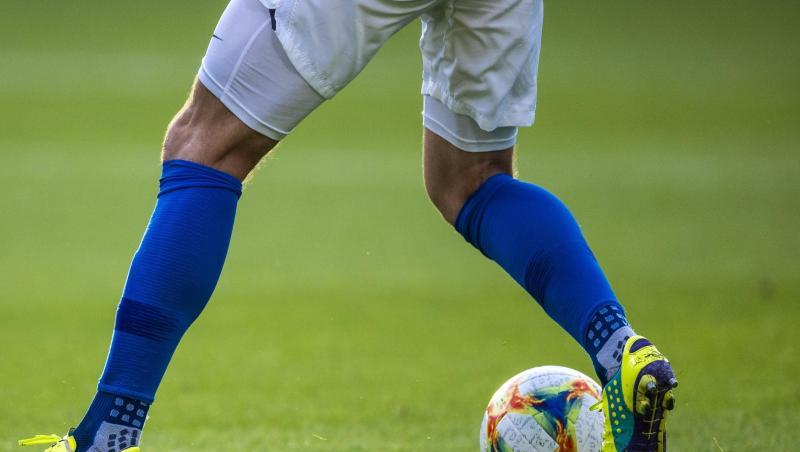 Ein Fußballspieler ist am Ball.