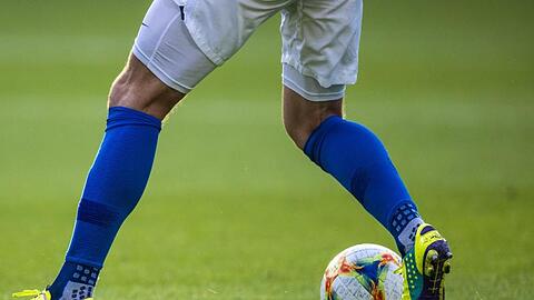Ein Fußballspieler ist am Ball.