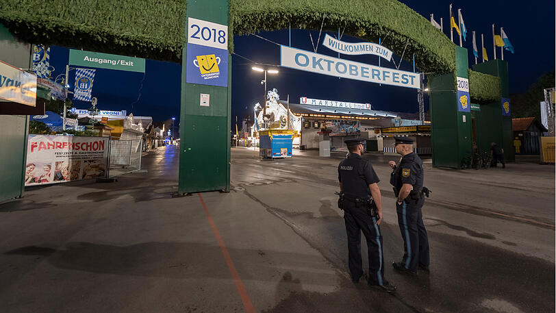 Die Ruhe vor dem Sturm: Polizisten stehen am frühen Samstagmorgen vorm Haupteingang der Wiesn.