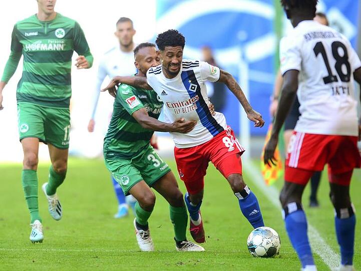Fürths Julian Green (M,l-r) und HSV-Spieler Jeremy Dudziak kämpfen um den Ball.