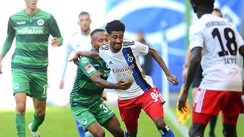 Fürths Julian Green (M,l-r) und HSV-Spieler Jeremy Dudziak kämpfen um den Ball.