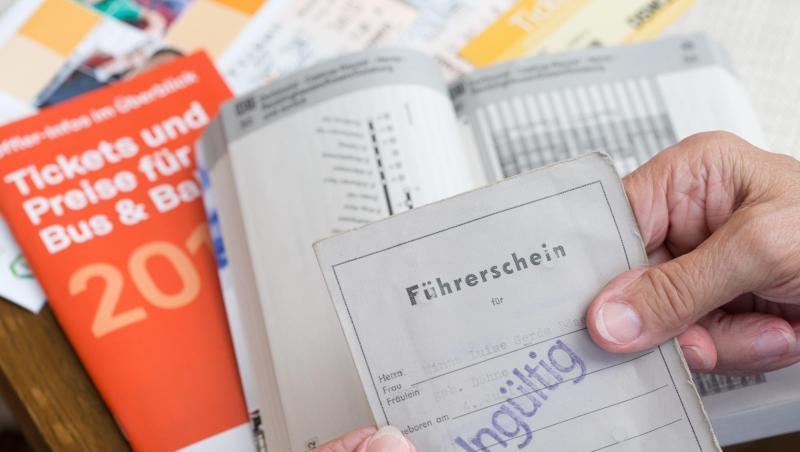 Eine ältere Person hält ihren entwerteten Führerschein in der Hand. Im Hintergrund ist ein Fahrplan des Öffentlichen Personen-Nahverkehrs zu sehen. Foto: Friso Gentsch/Archiv Eine ältere Person hält ihren entwerteten Führerschein in der Hand. Im Hintergrund ist ein Fahrplan des Öffentlichen Personen-Nahverkehrs zu sehen. Foto: Friso Gentsch/Archiv