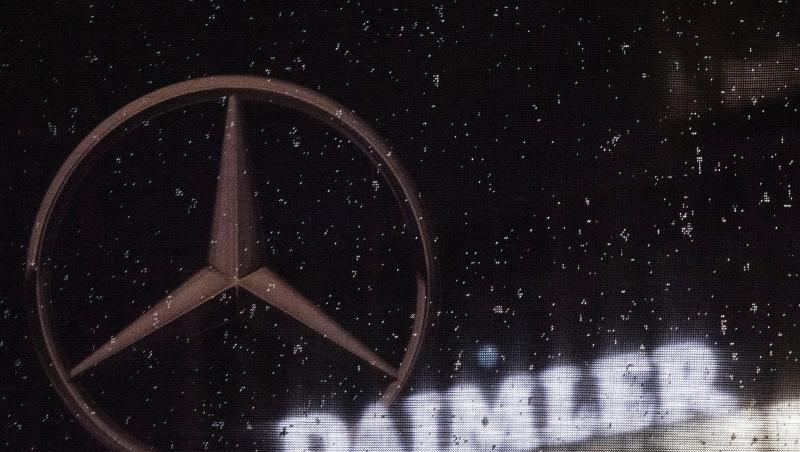 Das Logo der Daimler-AG ist an der Konzernzentrale zu sehen, im Vordergrund ist ein Mercedes-Stern auf einer Flagge abgebildet, die voller Regentropfen ist. Das Logo der Daimler-AG ist an der Konzernzentrale zu sehen, im Vordergrund ist ein Mercedes-Stern auf einer Flagge abgebildet, die voller Regentropfen ist.